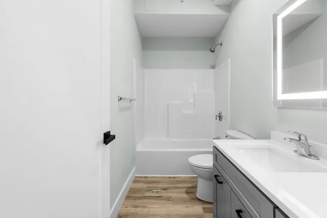 a bathroom with a sink a toilet and shower