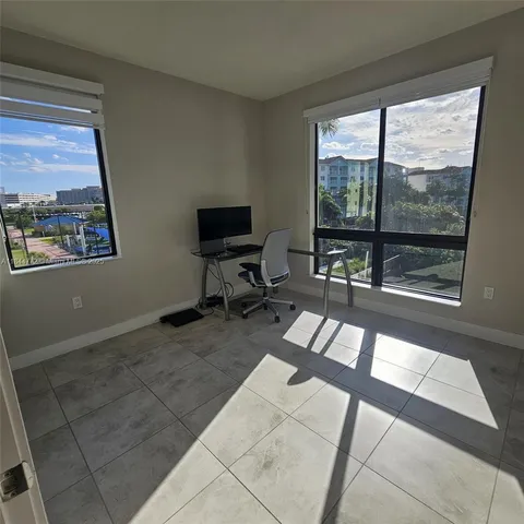 a view of a livingroom with workspace and a window