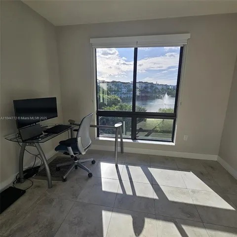 a view of a workspace with furniture and a window
