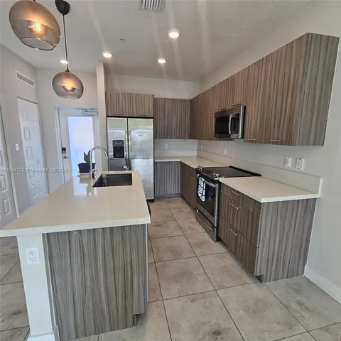 a kitchen with stainless steel appliances a stove a sink a microwave and cabinets