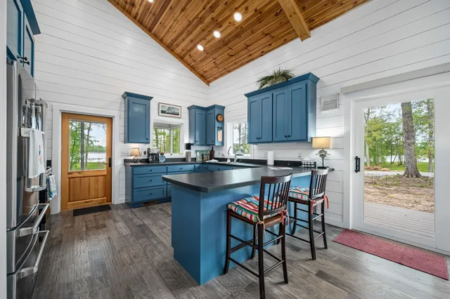 a kitchen with granite countertop wooden floors and wooden cabinets