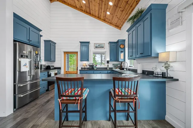 a kitchen with a table chairs refrigerator and cabinets