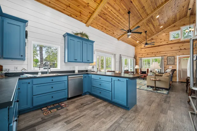 a kitchen with granite countertop wooden floors and wooden cabinets