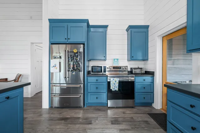 a kitchen with stainless steel appliances kitchen island granite countertop a refrigerator stove and oven