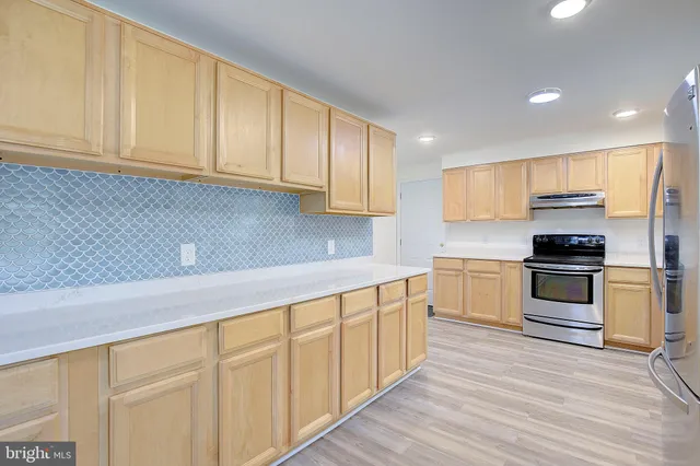 a kitchen with granite countertop white cabinets and stainless steel appliances