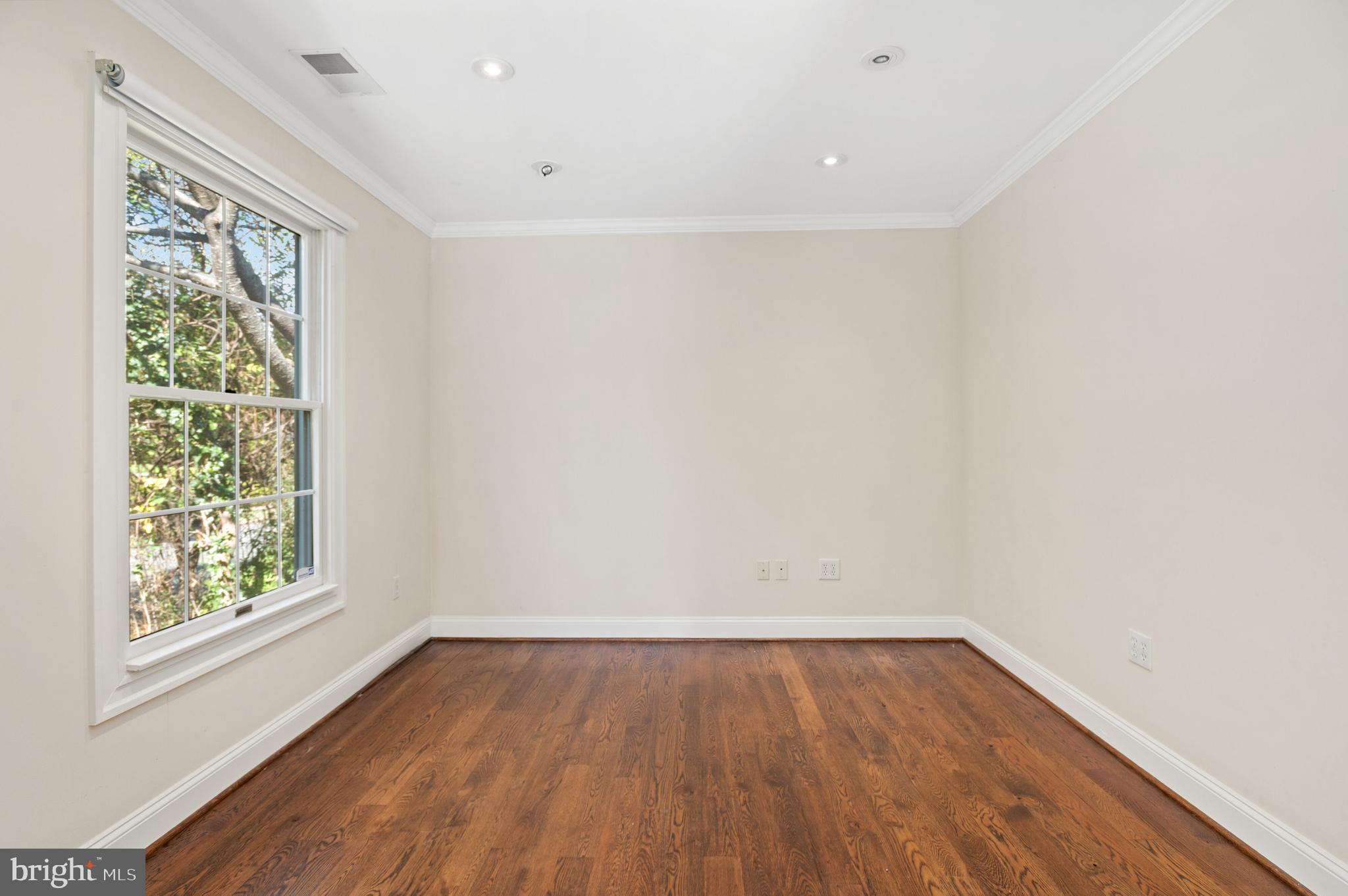 4849 Rodman Street Northwest Washington, DC 20016 - Photo 16 of 30 a view of an empty room with wooden floor and a window