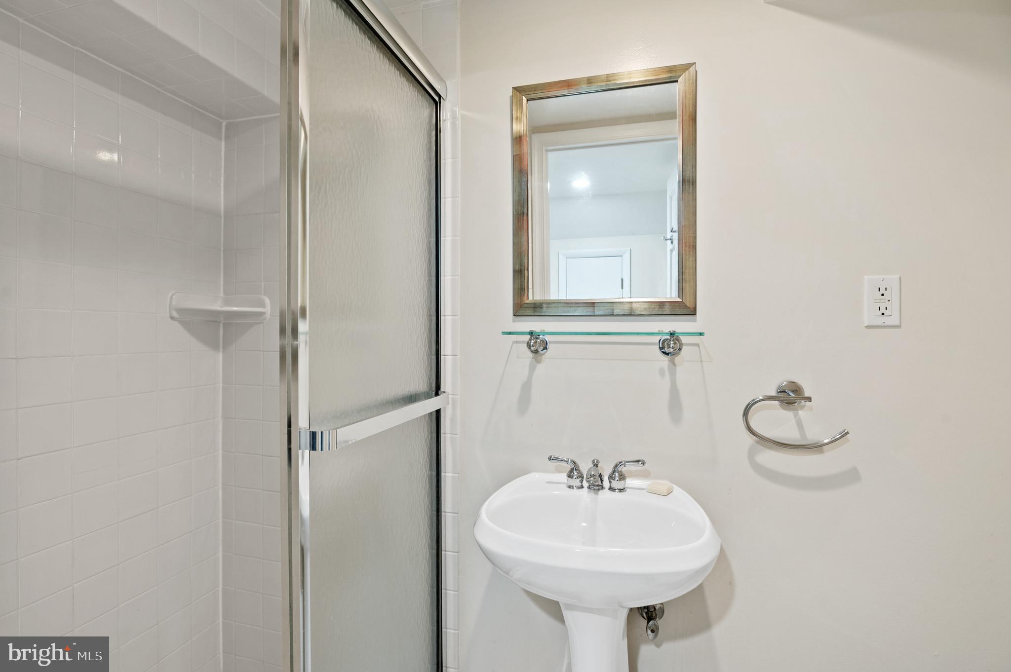 4849 Rodman Street Northwest Washington, DC 20016 - Photo 26 of 30 a bathroom with a sink a mirror and a shower
