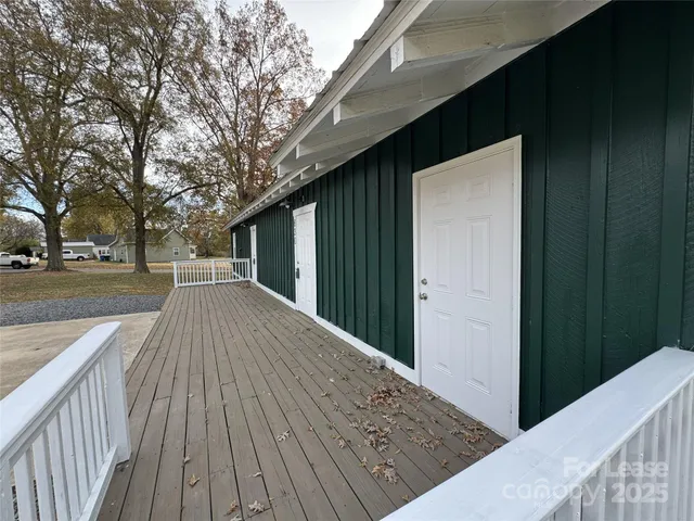 a view of backyard with a deck and wooden floor