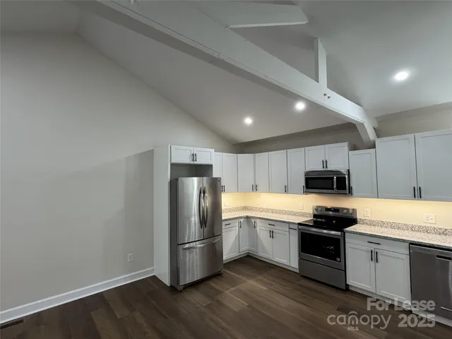 a kitchen with a refrigerator a stove top oven a sink and dishwasher