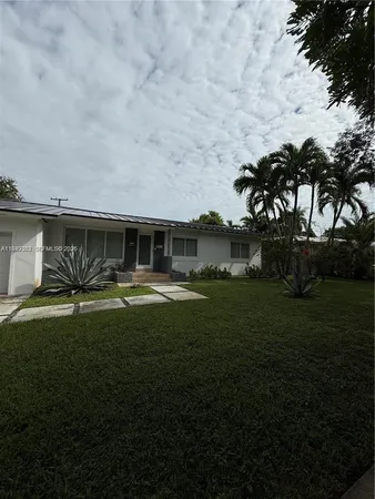 a front view of a house with a garden
