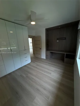 a view of empty room with wooden floor and cabinet