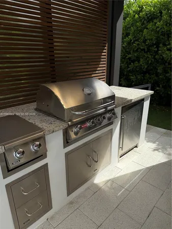 a view of a kitchen with a sink and dishwasher a flat tv screen