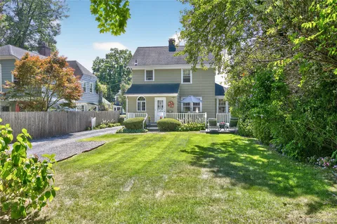 a front view of a house with a yard and green space