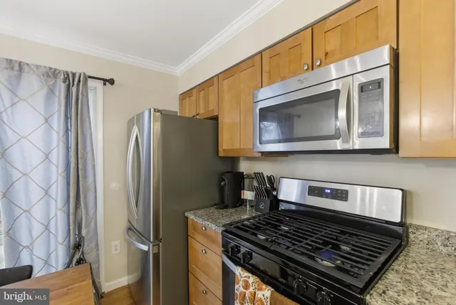 a kitchen with stainless steel appliances granite countertop a stove and a refrigerator
