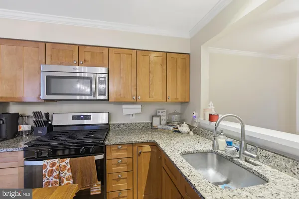 a kitchen with stainless steel appliances granite countertop a sink stove and cabinets