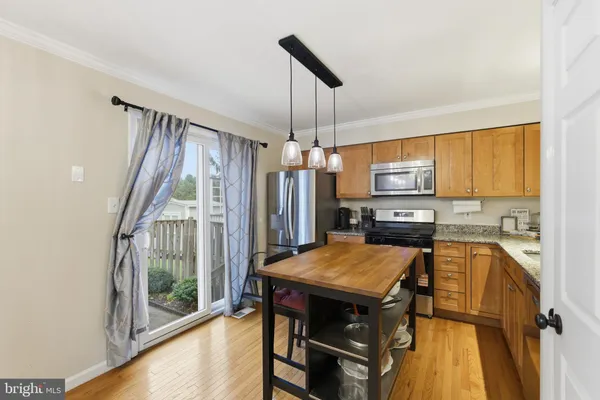 a kitchen with a table chairs appliances and cabinets