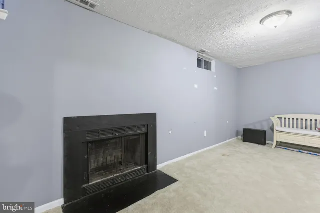 an empty room with a fireplace and wooden floor
