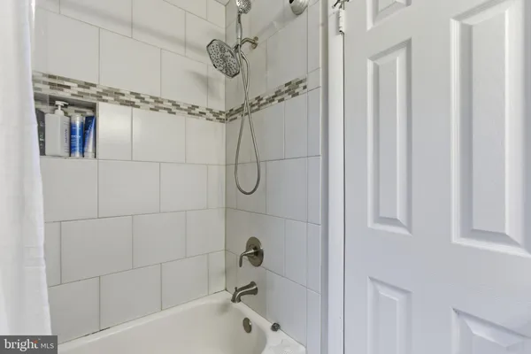 a bathroom with a bathtub a shower and a shower