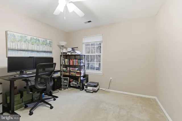 a view of a workspace with furniture and a window
