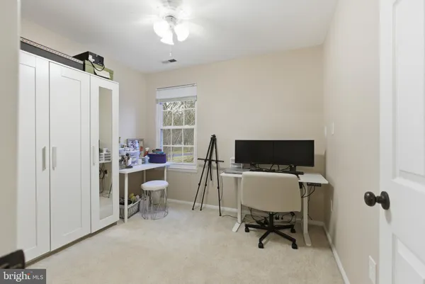 a view of a workspace with furniture and a window