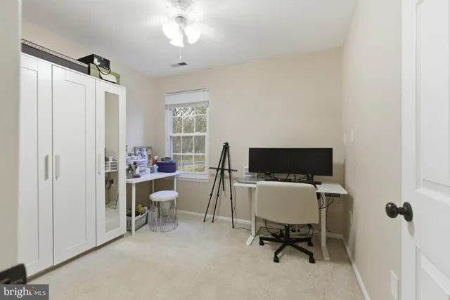 a view of a workspace with furniture and a window