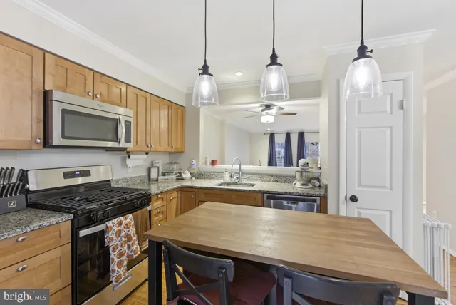 a kitchen with kitchen island a stove and a chandelier