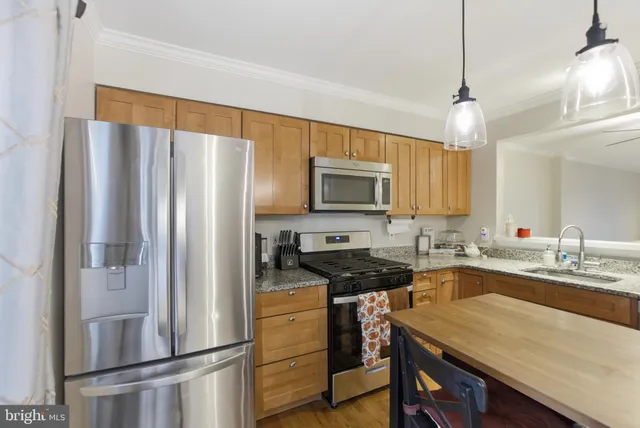 a kitchen with a refrigerator a sink a stove and cabinets