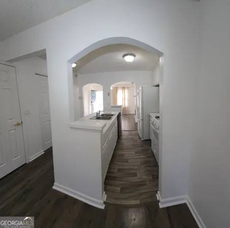 a hallway with a wooden floor and a living room