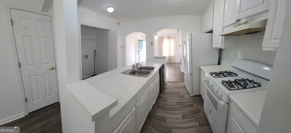 a kitchen with sink stove and refrigerator