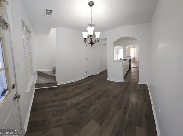 a view of a hallway with wooden floor and staircase
