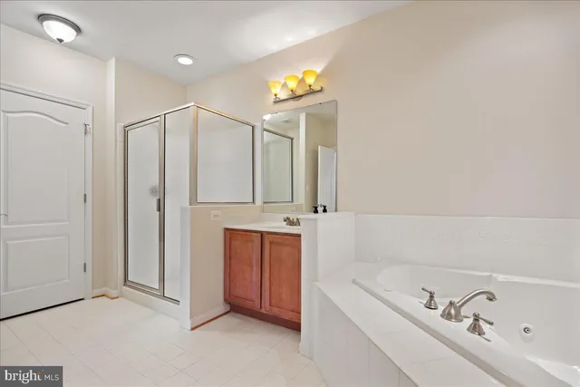 a bathroom with a tub a sink and mirror