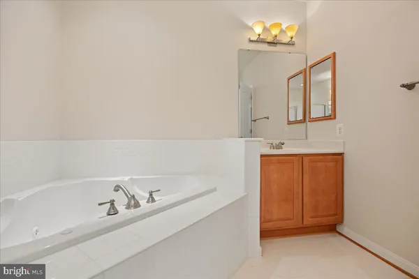 a bathroom with a bathtub sink and mirror