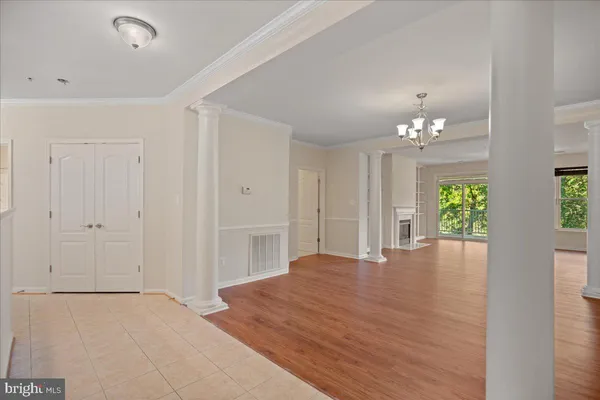 a view of an empty room with window and wooden floor