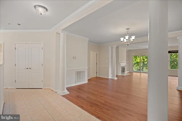 a view of an empty room with window and wooden floor
