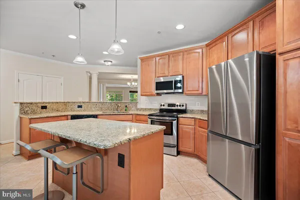 a kitchen with kitchen island a refrigerator stove microwave and sink