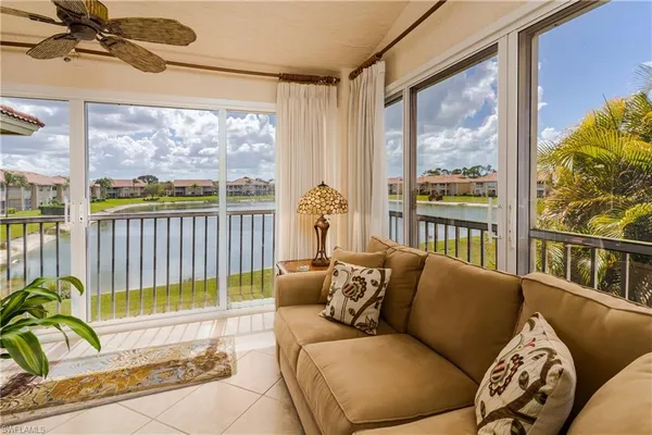 a living room with furniture and a floor to ceiling window