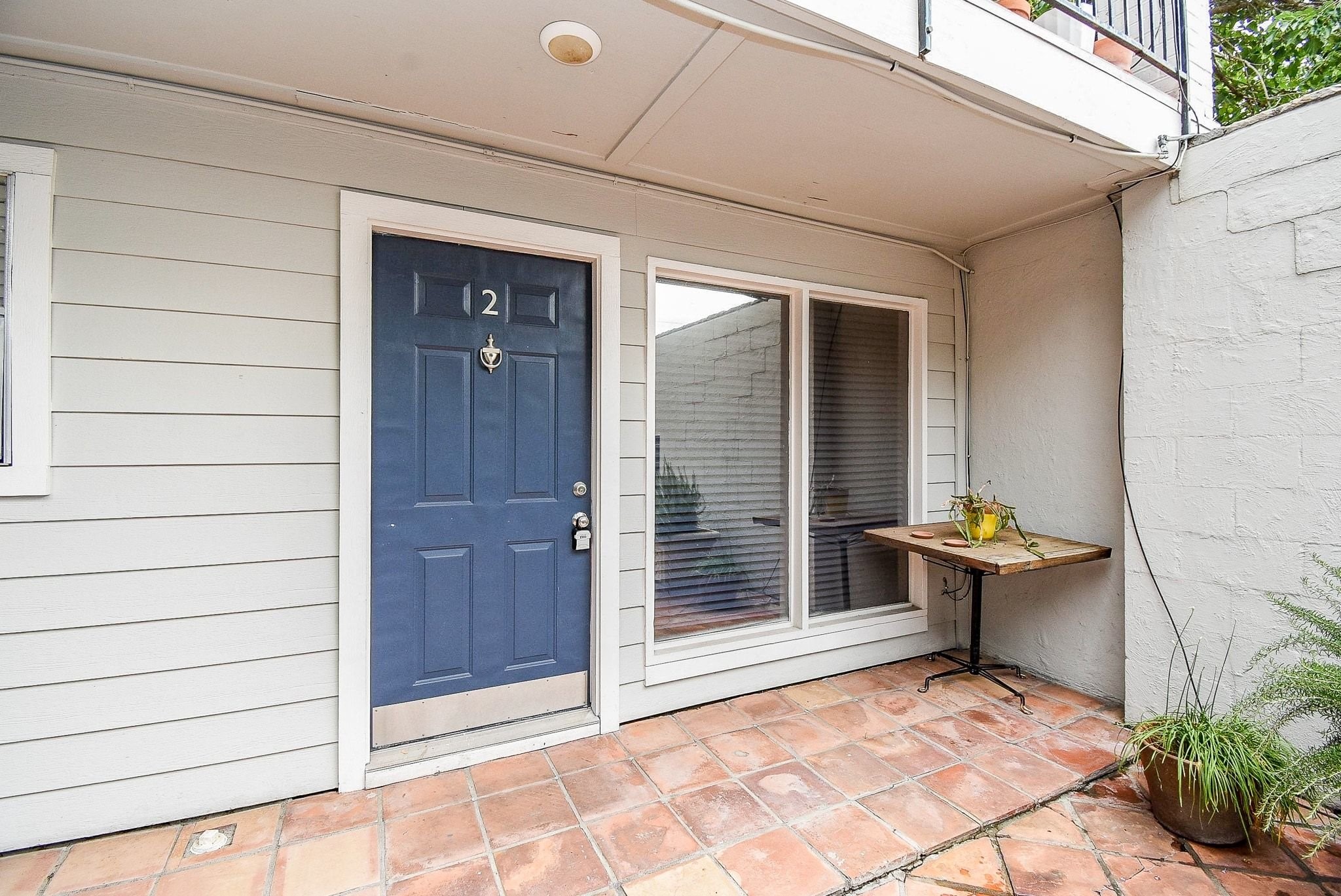 1404 Welch Street, Unit 2 Houston, TX 77006 - Photo 6 of 20 Private covered patio with terracotta tile flooring, creating a charming outdoor seating area just off the main living space.