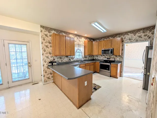 a kitchen with stainless steel appliances a sink a stove top oven a counter space and cabinets