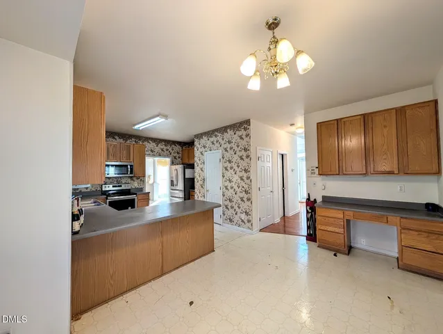 a view of a kitchen with a sink and dishwasher a refrigerator with white cabinets