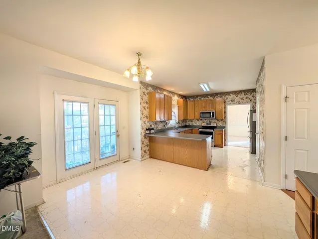 a kitchen with stainless steel appliances granite countertop a sink dishwasher a stove and a refrigerator with wooden floor