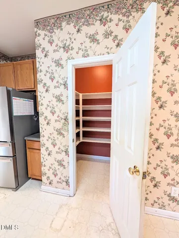 a large kitchen with kitchen island a large counter top and stainless steel appliances