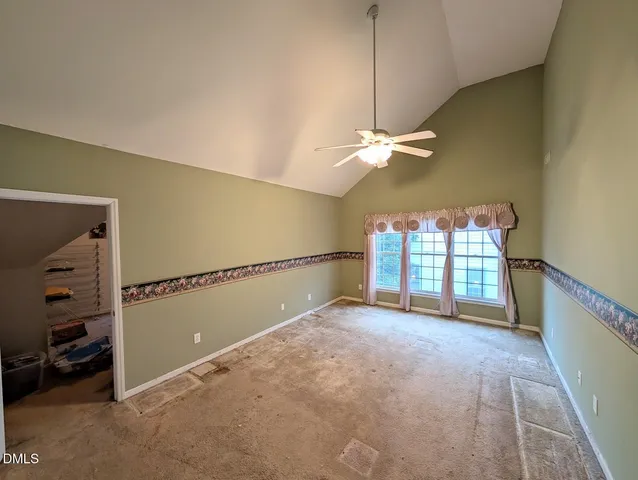 en empty room with windows and ceiling fan