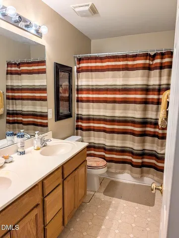 a view of a big room with windows and chandelier fan