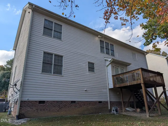 a view of a yard with plants and large trees