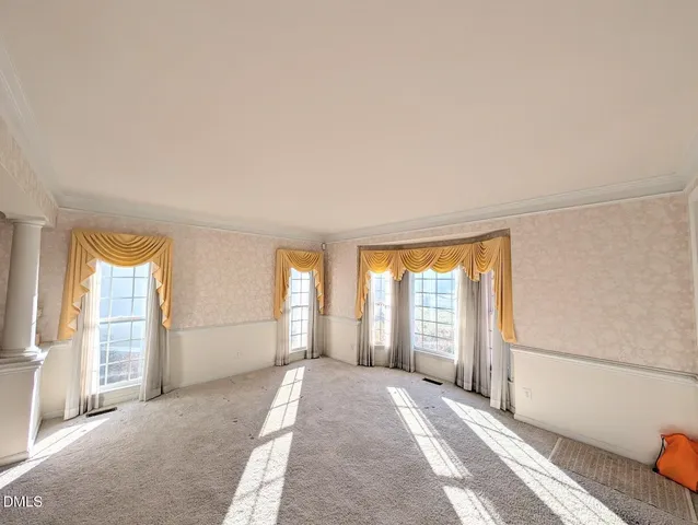 a view of a big room with wooden floor and windows