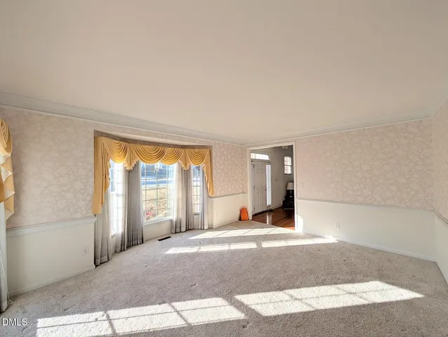 a view of an empty room and window and wooden floor