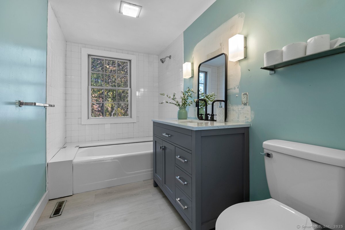 1166 Old Racebrook Road Woodbridge, CT 06525 - Photo 16 of 29 a bathroom with a toilet a sink a tub and mirror