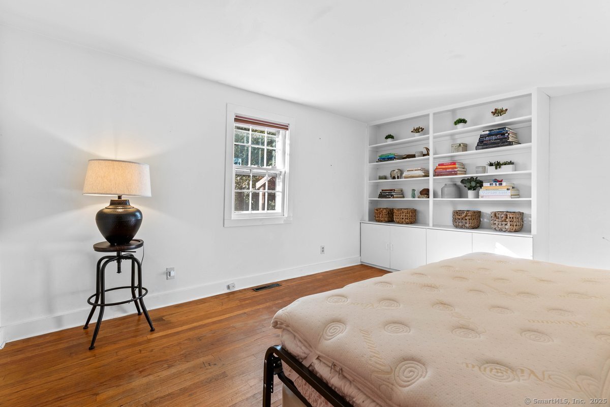 1166 Old Racebrook Road Woodbridge, CT 06525 - Photo 18 of 29 a bedroom with a bed and a bookshelf