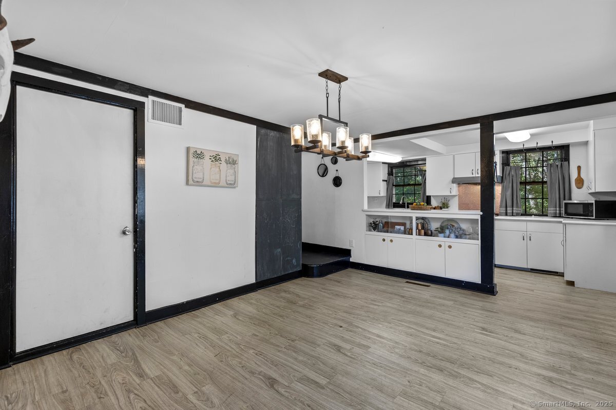 1166 Old Racebrook Road Woodbridge, CT 06525 - Photo 3 of 29 a view of a room with wooden floor and chandelier
