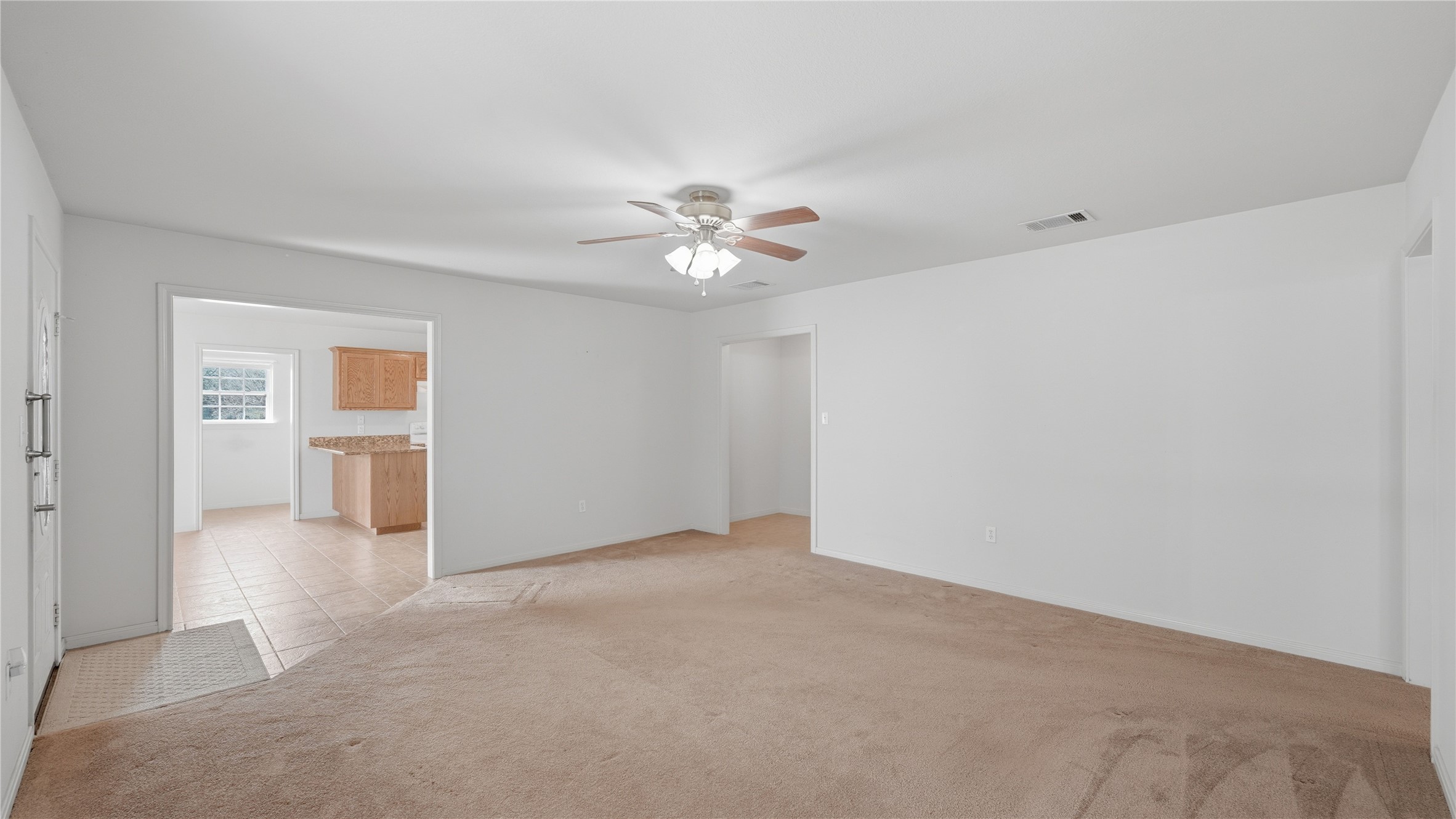 369 Young School House Road Smithville, TX 78957 - Photo 9 of 30 Spare room featuring ceiling fan, light carpet, and light tile patterned flooring